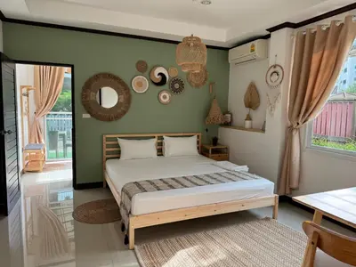 a bedroom with a large bed and a window at Jungle style apartments in Kamala in Kamala Beach