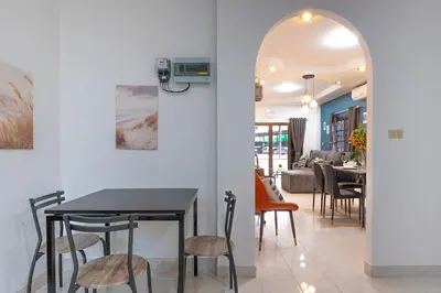 a dining room and living room with a table and chairs at Serenity Holiday Villa 1 D Karon Beach in Karon Beach
