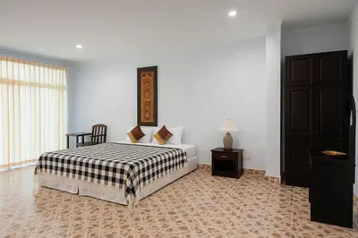 a bedroom with a bed with a black and white blanket at Kamala Orchid Guesthouse in Kamala Beach
