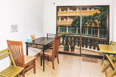 a dining room with a table and chairs and a window at Kamala Orchid Guesthouse in Kamala Beach