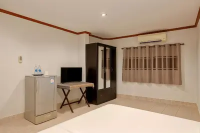 a living room with a refrigerator and a table at Kamala Orchid Guesthouse in Kamala Beach