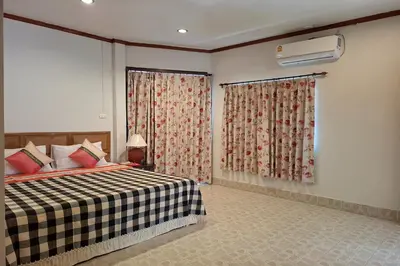 a bedroom with a bed and a window with curtains at Kamala Orchid Guesthouse in Kamala Beach