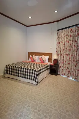 a bedroom with a bed with a checkered blanket at Kamala Orchid Guesthouse in Kamala Beach