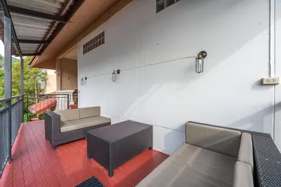 a balcony with two chairs and a couch and a table at Serenity Holiday Villa 2, Karon Beach in Karon Beach