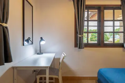 a room with a desk with a lamp and a window at Serenity Holiday Villa 2, Karon Beach in Karon Beach