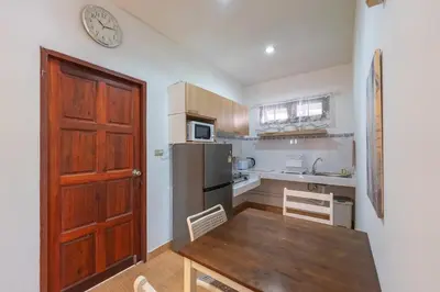 a kitchen with a table and a clock on the wall at Serenity Holiday Villa 2, Karon Beach in Karon Beach