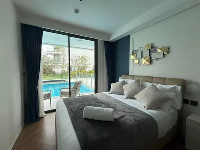 a bedroom with a large bed and a swimming pool at The Sunshine Beach 3-bedrooms Suite with Pool in Layan Beach