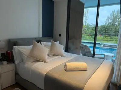 a bedroom with a bed with a yellow towel on it at The Sunshine Beach 3-bedrooms Suite with Pool in Layan Beach