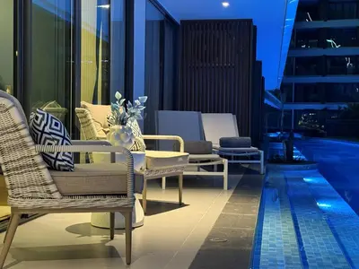 a balcony with chairs and a pool on a building at The Sunshine Beach 3-bedrooms Suite with Pool in Layan Beach