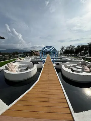 a walkway leading to a building with a row of boats at The Sunshine Beach 3-bedrooms Suite with Pool in Layan Beach