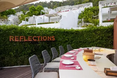 a long table with chairs and plates on it at The Nai Harn in Nai Harn Beach