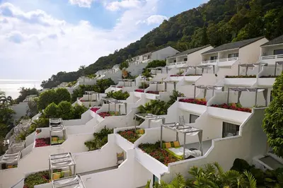 a row of white apartment buildings with flowers on the balconies at The Nai Harn in Nai Harn Beach