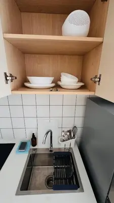 a kitchen counter with a sink and plates on shelves at Beautiful Sea 1BR apart A6 in Kamala Beach