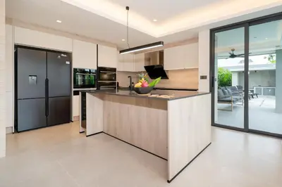 an open kitchen with a large island in a house at Riverhouse Phuket - Private Pool Villas by Escape Villas in Laguna Phuket