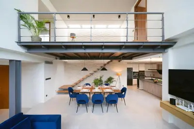 a dining room and kitchen with a table and blue chairs at Riverhouse Phuket - Private Pool Villas by Escape Villas in Laguna Phuket