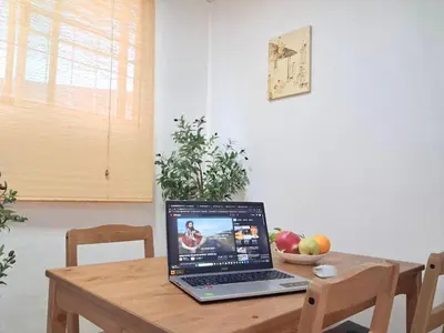 a laptop computer sitting on a wooden table with a bowl of fruit at Dalbit Thai Stay 2 Bedroom Patong house - 8mins walk to Jungcyelon Bangla Rd in Patong Beach