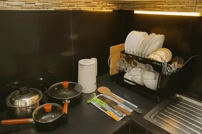 a kitchen counter with utensils and a rack of dishes at Dalbit Thai Stay 2 Bedroom Patong house - 8mins walk to Jungcyelon Bangla Rd in Patong Beach