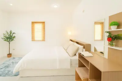 a white bedroom with a bed and a desk at Dalbit Thai Stay 2 Bedroom Patong house - 8mins walk to Jungcyelon Bangla Rd in Patong Beach