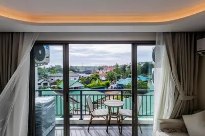 a room with a balcony with a view at Modern 2BR apartment on Kamala Beach in Kamala Beach