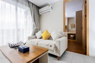 a living room with a couch and a table at Modern 2BR apartment on Kamala Beach in Kamala Beach
