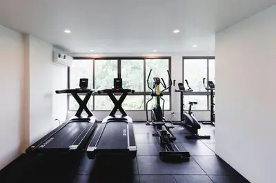 a gym with treadmills and exercise bikes in a room at Modern 2BR apartment on Kamala Beach in Kamala Beach
