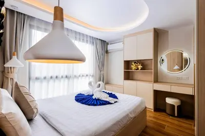 a bedroom with a white bed with a large light at Modern 2BR apartment on Kamala Beach in Kamala Beach