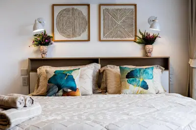 a bedroom with a bed with pillows and pictures on the wall at The Signature Suite in Ban Mai Salae