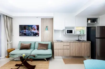 a living room with a couch and a kitchen at The Signature Suite in Ban Mai Salae