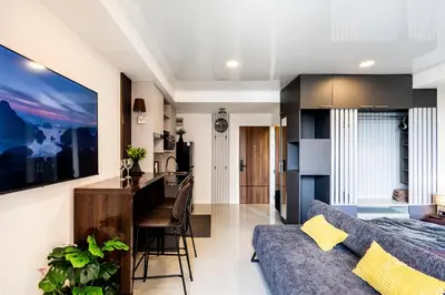a living room and kitchen with a couch and a table at The Signature Suite in Ban Mai Salae
