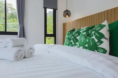 a white bed with two towels on top of it at Wink Hill 4 Penthouse Patong Beach 4Beds in Patong Beach