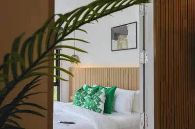 a bedroom with a bed with green and white pillows at Wink Hill 4 Penthouse Patong Beach 4Beds in Patong Beach