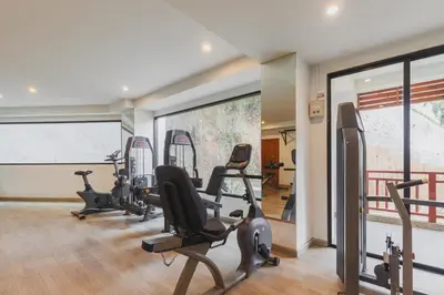 a gym with treadmills and exercise bikes in a room at C233 Condo 650m Surin 1BR with Pool &Gym Prime Location in Surin Beach
