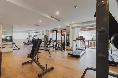 a gym with treadmills and ellipticals in a room at C233 Condo 650m Surin 1BR with Pool &Gym Prime Location in Surin Beach
