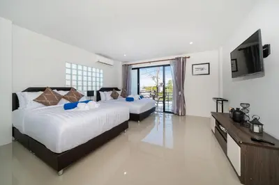 two beds in a hotel room with a television at Rawai Pool House with 3 Bedrooms in Ban Saiyuan (1)