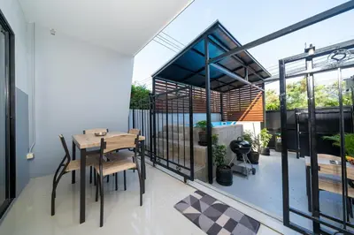 a room with a table and chairs on a balcony at Rawai Pool House with 3 Bedrooms in Ban Saiyuan (1)