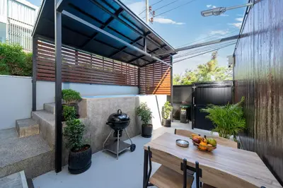 an outdoor patio with a table and a grill at Rawai Pool House with 3 Bedrooms in Ban Saiyuan (1)