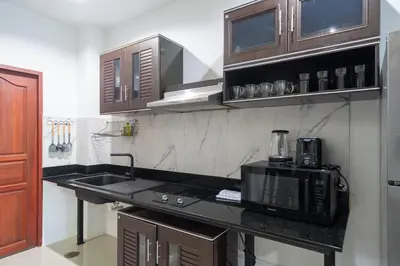 a kitchen with a sink and a microwave at Rawai Pool House with 3 Bedrooms in Ban Saiyuan (1)