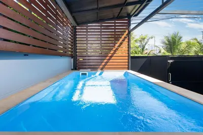 an indoor swimming pool with blue water in a house at Rawai Pool House with 3 Bedrooms in Ban Saiyuan (1)