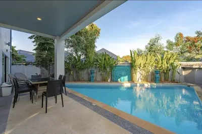 a house with a swimming pool with a table and chairs at V161 Quiet 4BR with Pool Table, 3 Min to Rawai Beach in Rawai Beach