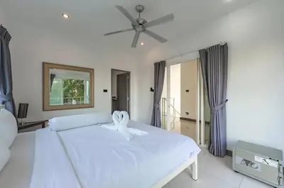 a bedroom with a white bed with a ceiling fan at V161 Quiet 4BR with Pool Table, 3 Min to Rawai Beach in Rawai Beach