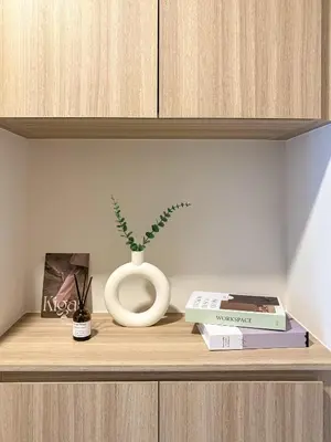 a shelf with a vase and books on it at The Base Rise A Cozy Room near Central Phuket Studio Room Pool View in Ban Rangeng
