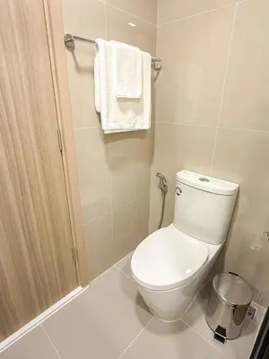 a white bathroom with a toilet and a towel at The Base Rise A Cozy Room near Central Phuket Studio Room Pool View in Ban Rangeng