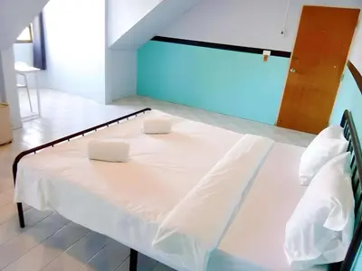 a white bed in a room with two pillows on it at Mitr Inn Phuket OldTown - มิตรอินน์ โอลด์ทาวน์ in Phuket Town