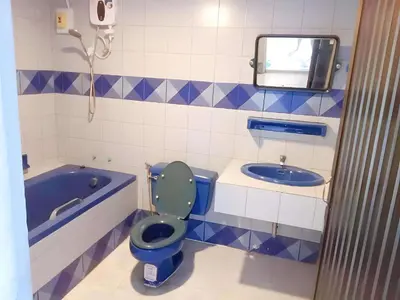 a bathroom with a blue toilet and a tub at Mitr Inn Phuket OldTown - มิตรอินน์ โอลด์ทาวน์ in Phuket Town