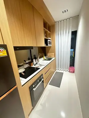 a kitchen with wooden cabinets and a stove top oven at MODERN NEW RELAX VILLA SoL & PooL in Nai Yang Beach