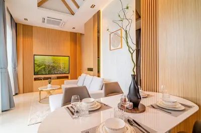 a living room with a table and chairs and a television at MODERN NEW RELAX VILLA SoL & PooL in Nai Yang Beach