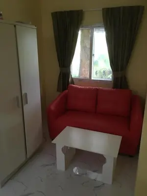 a red couch in a living room with a window at Kathu Waterfall Bungalow in Kathu