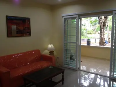 a living room with a couch and a sliding glass door at Kathu Waterfall Bungalow in Kathu