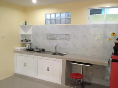 a kitchen with a sink and a red stool at Kathu Waterfall Bungalow in Kathu