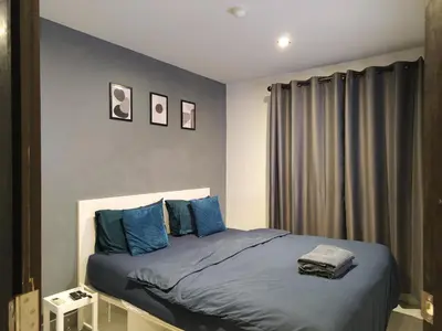 a bedroom with a bed with blue pillows at Chalong Bay - One bedroom on 7 Floor at Tower 1 in Ban Klang